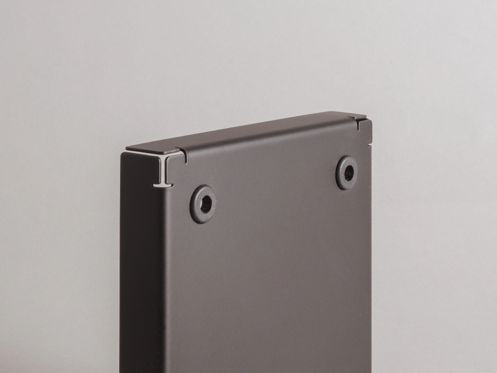 Keyboard standing on-end on a table next to a lamp, bottom side facing viewer
