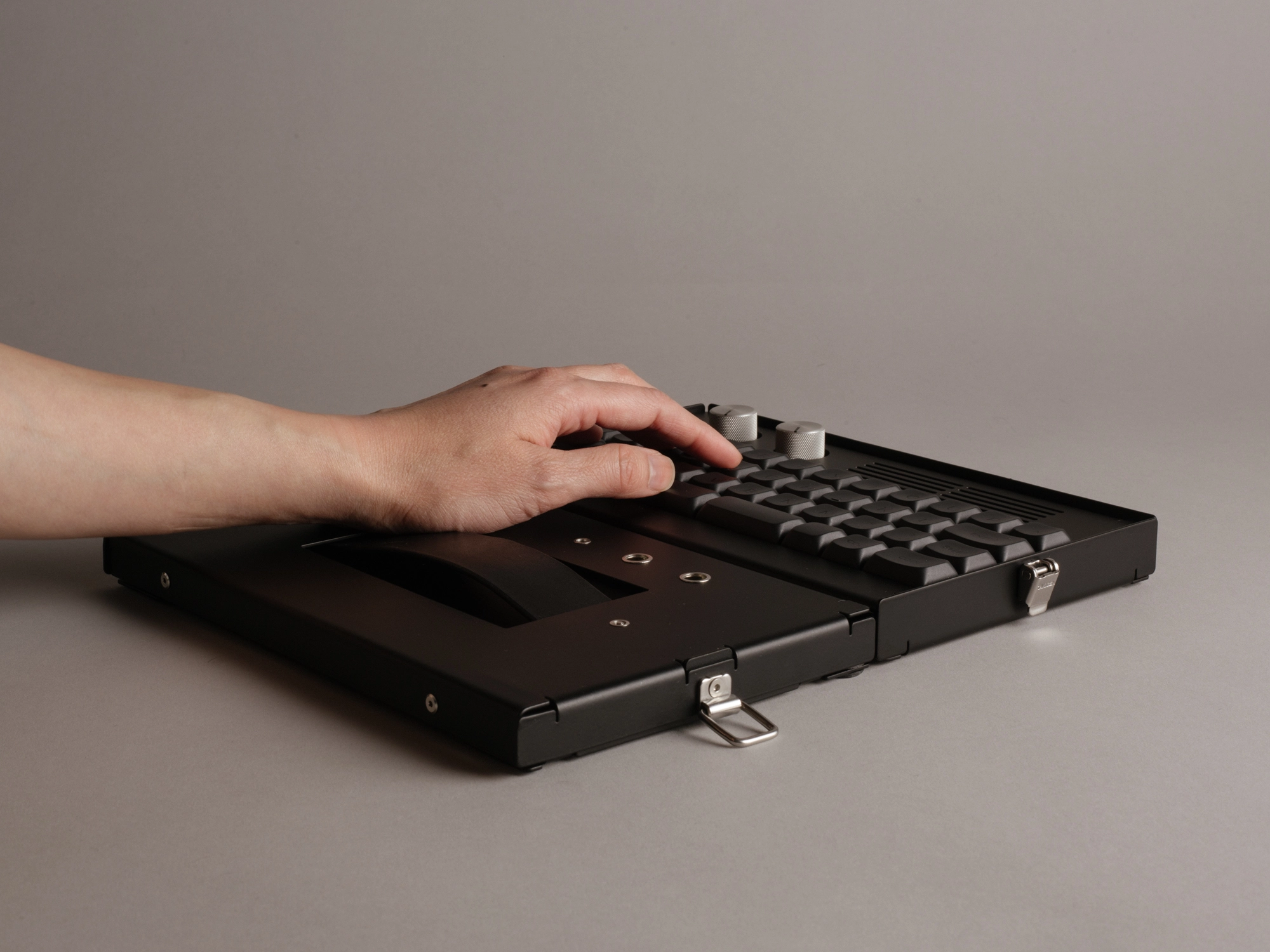 Keyboard standing on-end on a table next to a lamp, bottom side facing viewer