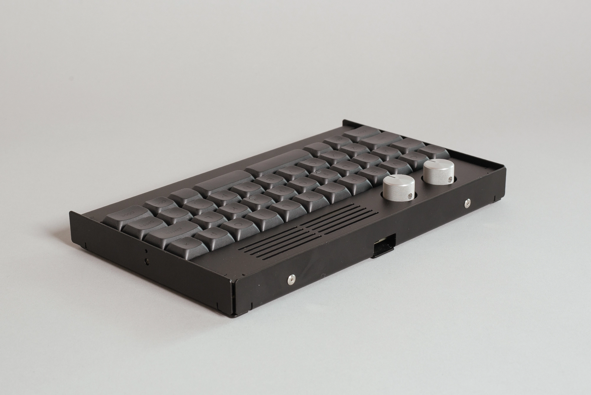 Black keyboard sitting on a grey background